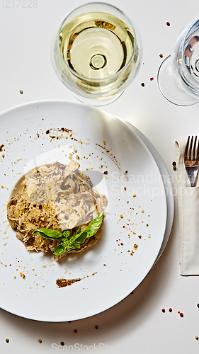 Image of Tagliatelle with mushrooms and decorated with basil leaves.