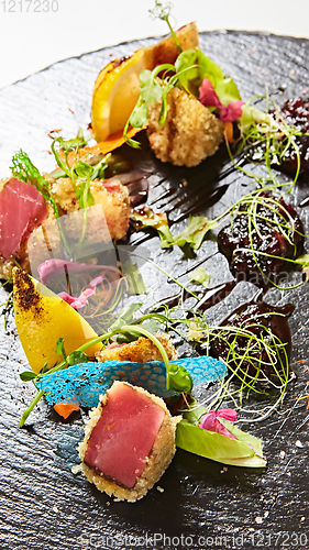 Image of Close up of rare seared Ahi tuna slices with fresh vegetable salad on a plate.