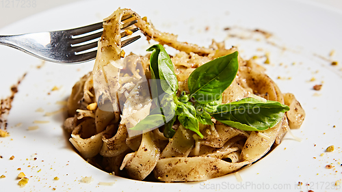 Image of Tagliatelle with mushrooms and decorated with basil leaves.