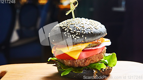 Image of Japanese Black Burger with Cheese. Cheeseburger from Japan with black bun on dark background.