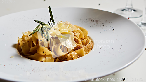 Image of Close-up italian pasta plate with grated parmesan cheese and basil leaf