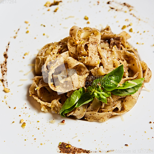 Image of Tagliatelle with mushrooms and decorated with basil leaves.