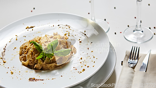 Image of Tagliatelle with mushrooms and decorated with basil leaves.