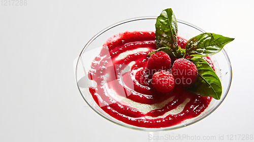 Image of Delicious Italian dessert Panna Cotta with raspberry in small transparent glass