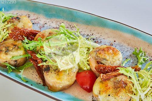 Image of Fried scallops with butter lemon spicy sauce served with green salad. Top view, copy space.