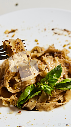 Image of Tagliatelle with mushrooms and decorated with basil leaves.