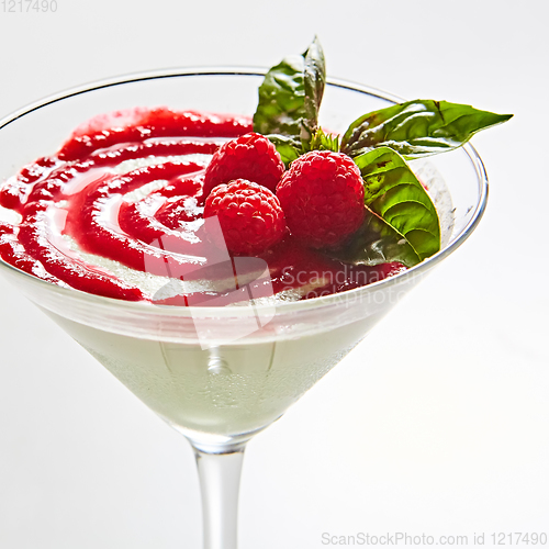 Image of Delicious Italian dessert Panna Cotta with raspberry in small transparent glass