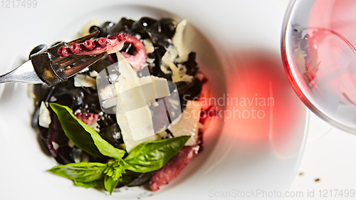 Image of Pasta with black cuttlefish ink, octopuses and parmesan.