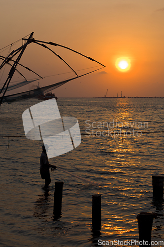 Image of Fisherman and chinese fishnets on sunset. Kochi, Kerala, India
