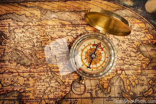 Image of Old vintage golden compass on ancient map