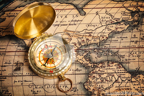 Image of Old vintage golden compass on ancient map