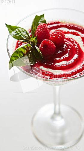 Image of Delicious Italian dessert Panna Cotta with raspberry in small transparent glass