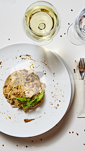 Image of Tagliatelle with mushrooms and decorated with basil leaves.