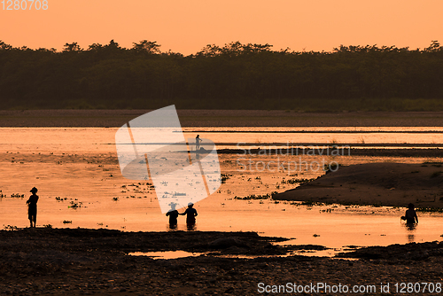 Image of Asian women fishing in the river, silhouette at sunset