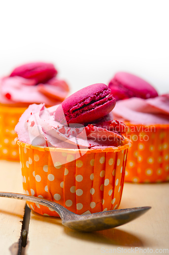 Image of pink berry cream cupcake with macaroon on top