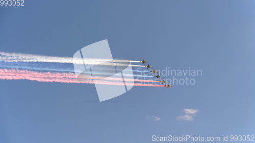 Image of Stormtroopers planes Su-25 fly in sky leaving trail of smoke as tricolor Russian flag