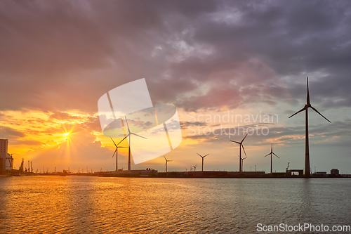 Image of Wind turbines in Antwerp port on sunset.