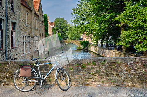 Image of Bicyccle on a bridge near canal and old houses. Bruges Brugge , Belgium