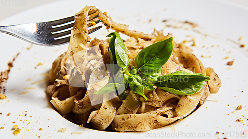 Image of Tagliatelle with mushrooms and decorated with basil leaves.