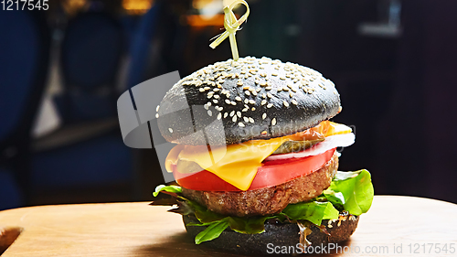 Image of Japanese Black Burger with Cheese. Cheeseburger from Japan with black bun on dark background.