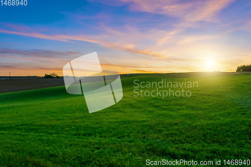 Image of sunset over agricultural green field