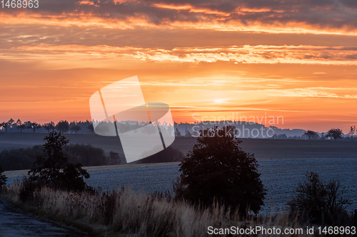 Image of Autumn foggy and misty sunrise landscape