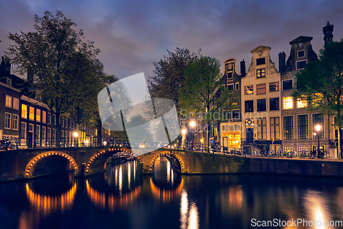 Image of Amterdam canal, bridge and medieval houses in the evening