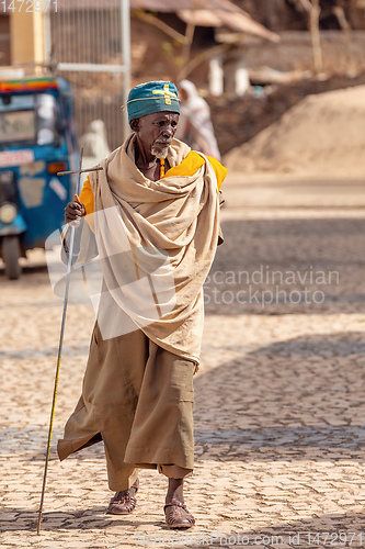 Image of Orthodox monk walk on empty street of Aksum, Ethiopia