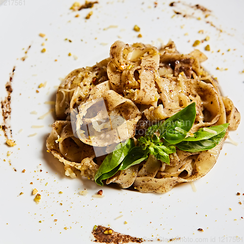 Image of Tagliatelle with mushrooms and decorated with basil leaves.