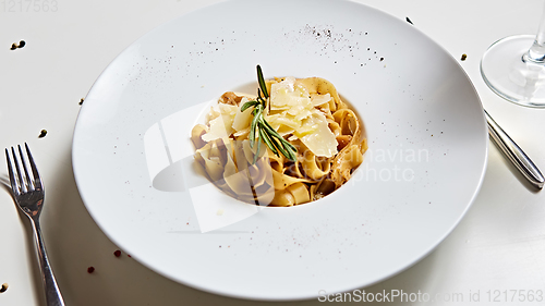 Image of Close-up italian pasta plate with grated parmesan cheese and basil leaf