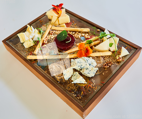 Image of Cheese selection on wooden rustic board. Cheese platter with different cheeses on wood.