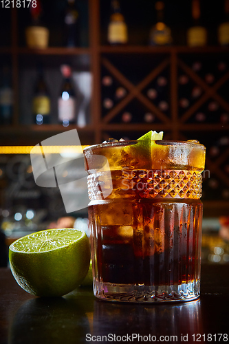 Image of High angle view of a glass of Cuba Libre cocktail with rum, coke, lemon juice and ice cubes