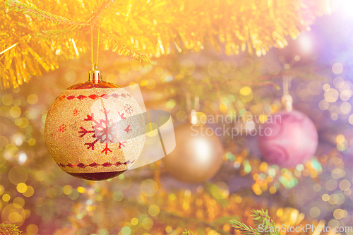 Image of Christmas-tree decoration bauble on decorated Christmas tree bac