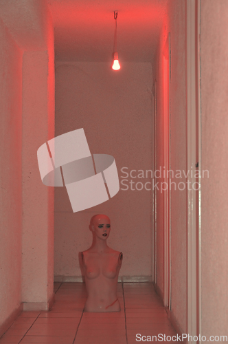 Image of broken doll under red light