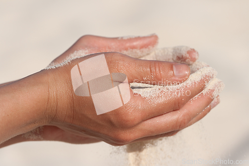 Image of Sand running through hands