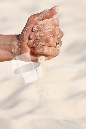 Image of Sand running through hands