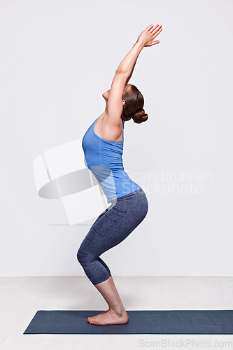 Image of Woman doing ashtanga vinyasa yoga asana Utkatasana