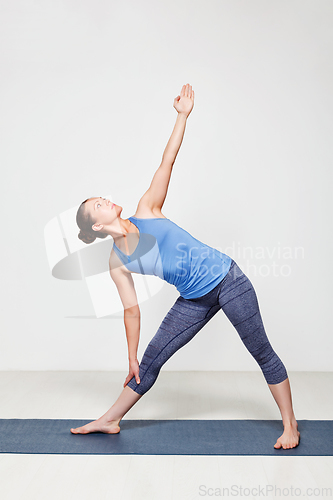 Image of Woman doing yoga asana utthita trikonasana