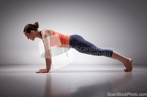 Image of Woman does yoga asana Utthita Chaturanga Dandasa