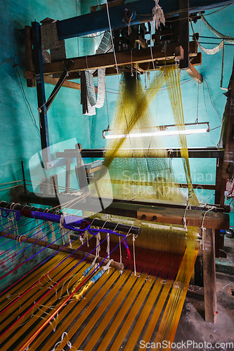 Image of Man weaving silk sari on loom in India