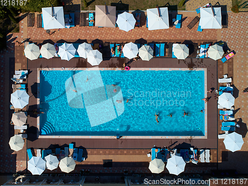 Image of Aerial view on people in swimming pool. Top view of people sunbathing pool.