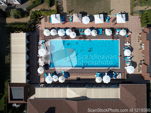 Image of Aerial view on people in swimming pool. Top view of people sunbathing pool.