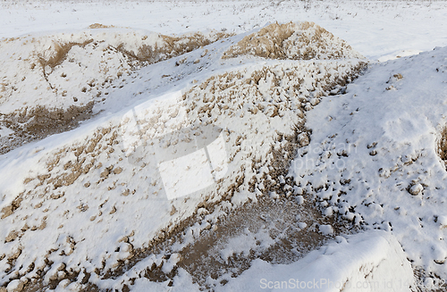 Image of Sand under the snow - a pile of sand for construction, covered with snow. A close-up photograph in the winter season
