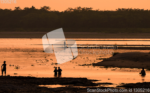 Image of Asian women fishing in the river, silhouette at sunset