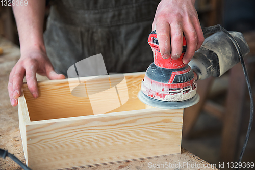 Image of Worker grinds the wood box