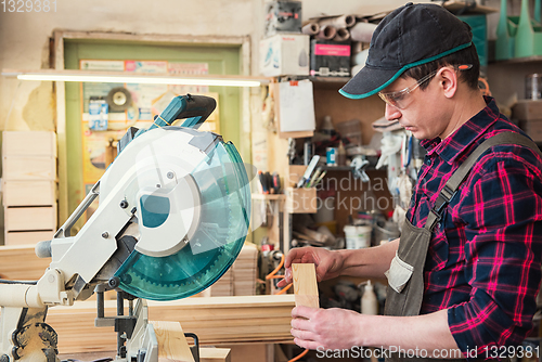 Image of Carpenter worker cutting wooden board