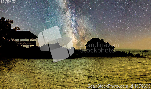 Image of Silhouette of coast over ocean with starry sky