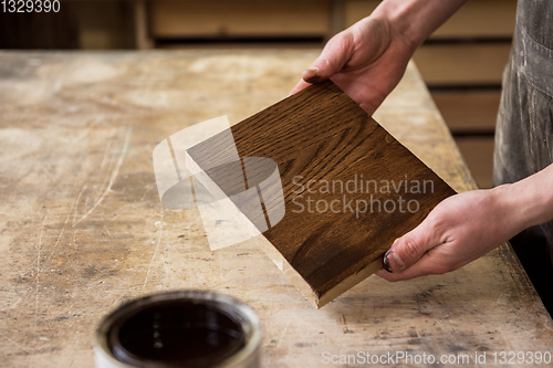 Image of Carpenter painting wooden