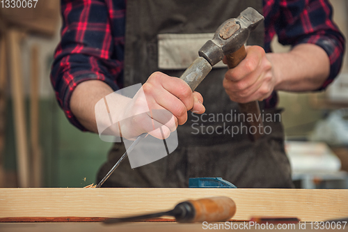 Image of The worker makes measurements of a wooden board