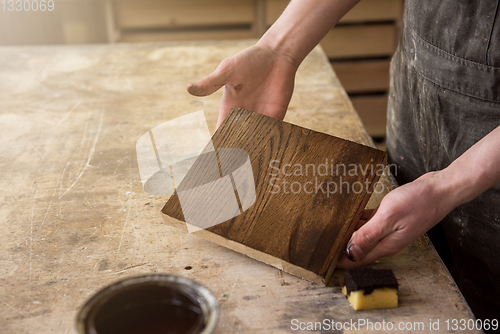 Image of Carpenter painting wooden